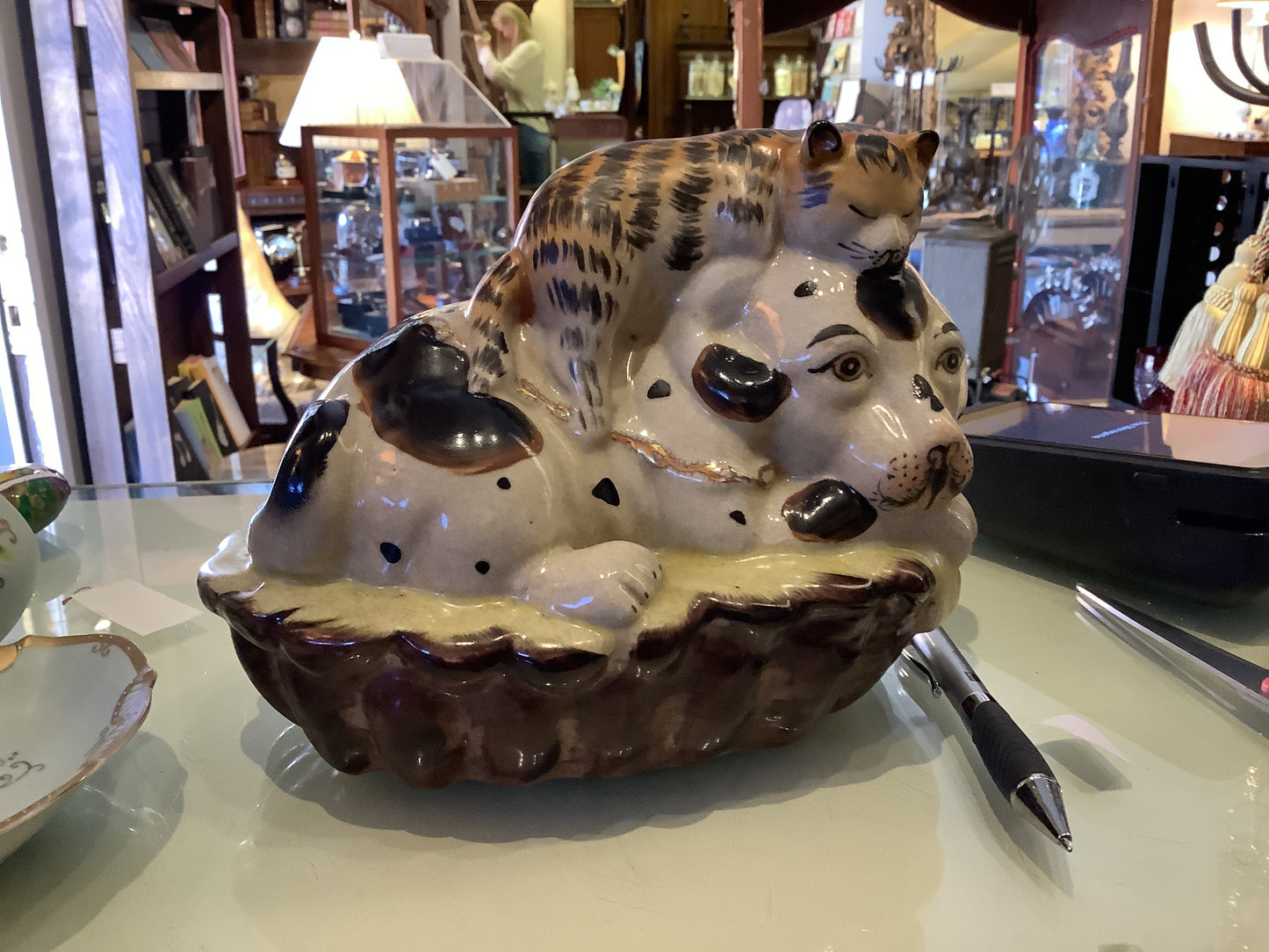 656. Staffordshire style dog / cat in basket